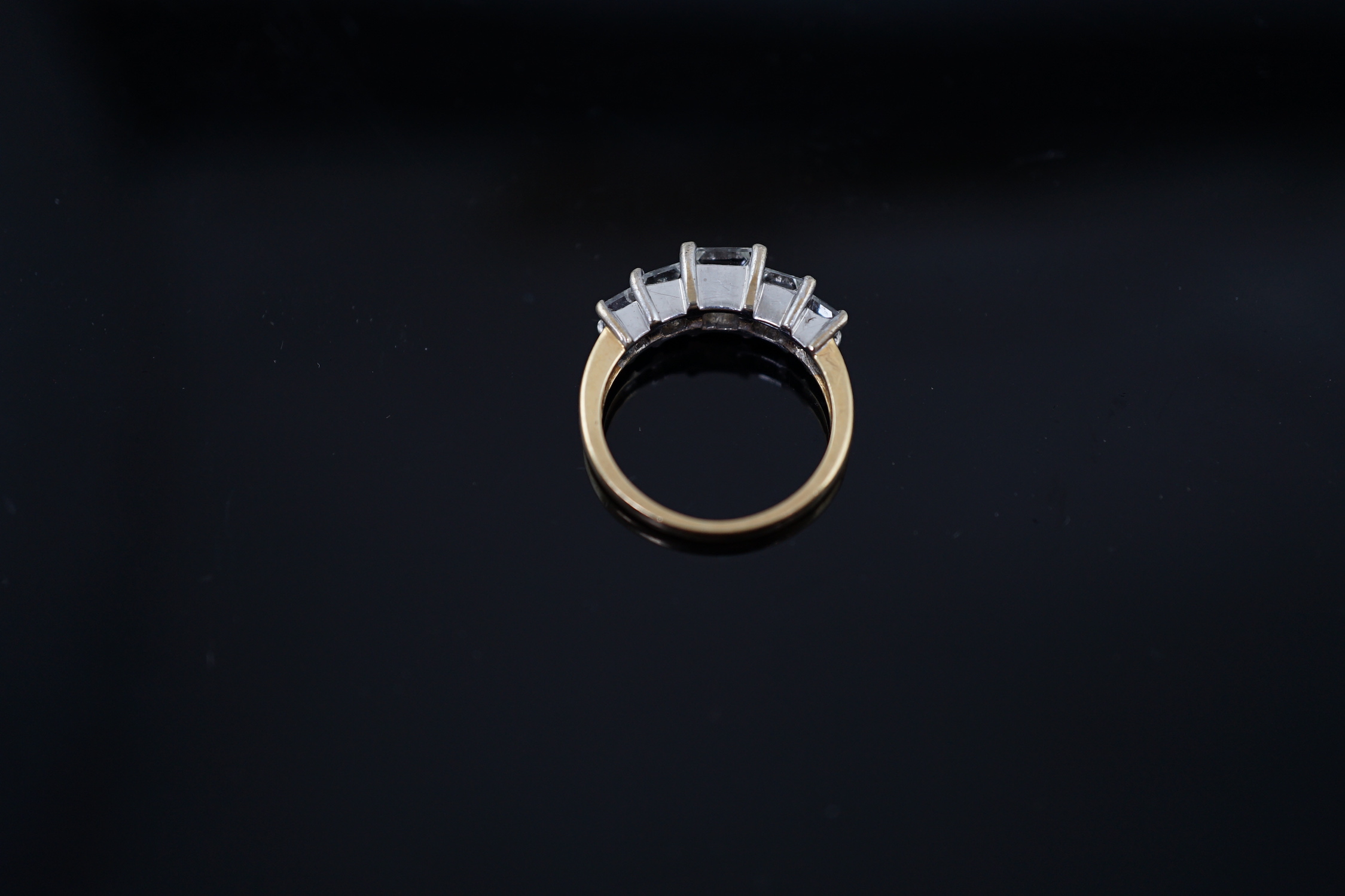 A modern 18ct gold and graduated five stone princess cut diamond set half hoop ring